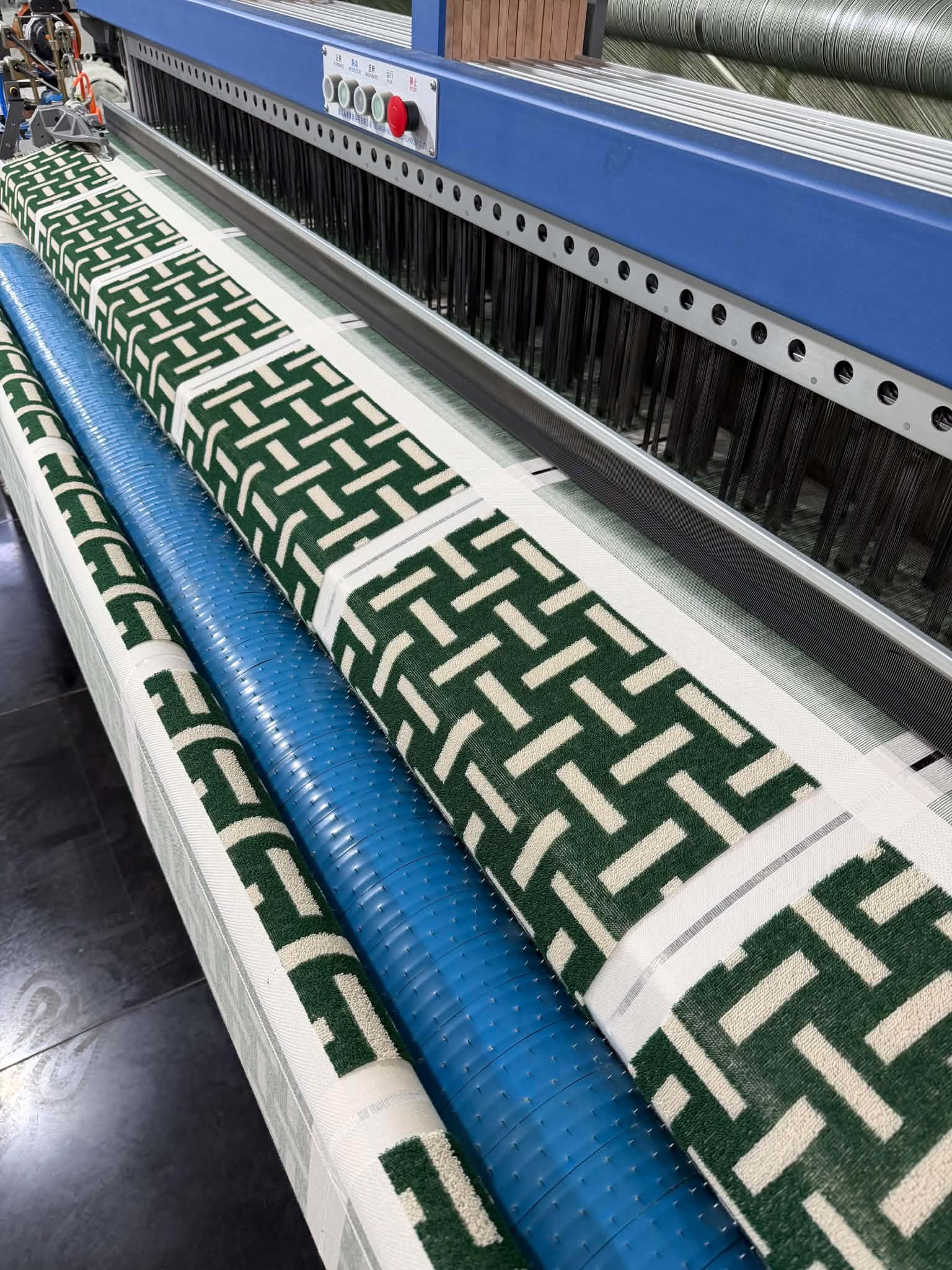 Green geometric towels being woven on a computer-controlled jacquard loom