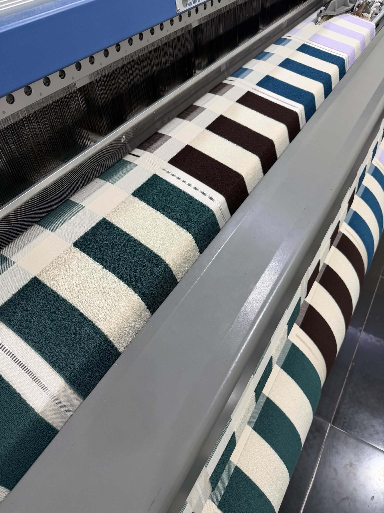Striped towels in several colourways being produced on a weaving machine